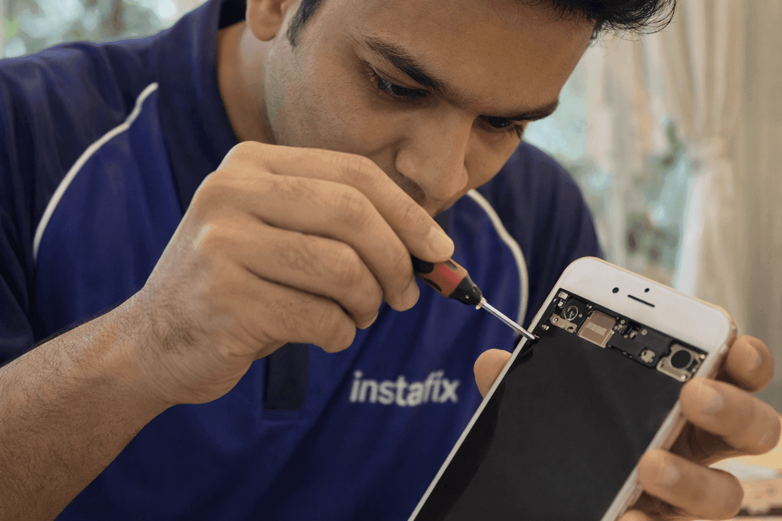 Technician working on a phone with a precision tool