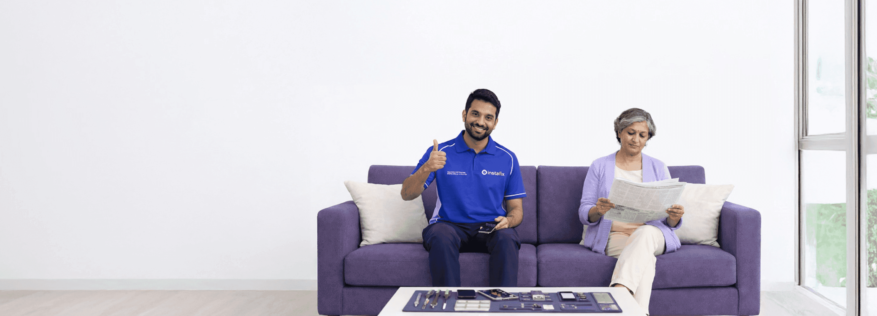 Instafix technician repairing a phone beside a customer at home