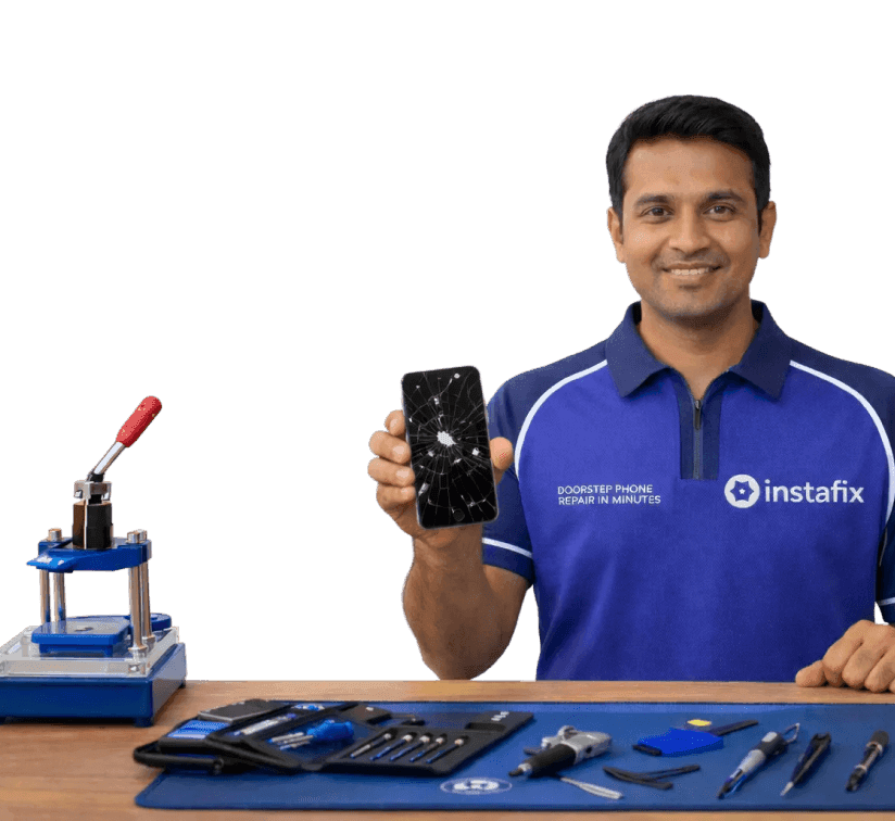 Instafix technician holding a repaired phone at a workbench